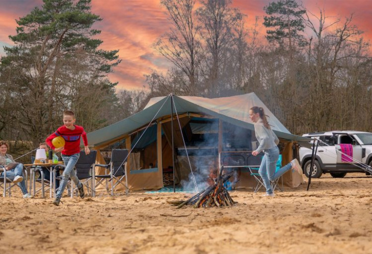Campooz Red Ruby vouwwagen ondergaande zon spelende kinderen kampvuurtje