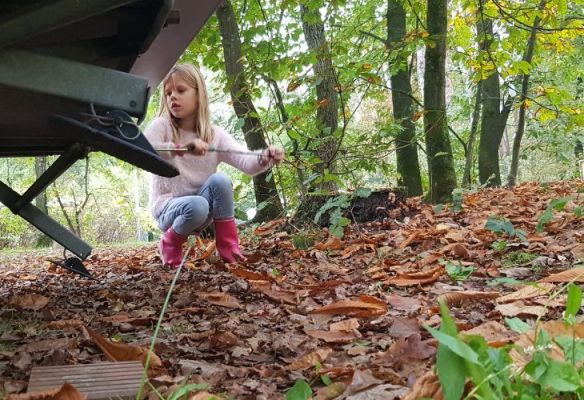 Kamperen kinderen herfst caravan pootjes opdraaien herfstbladeren laarzen