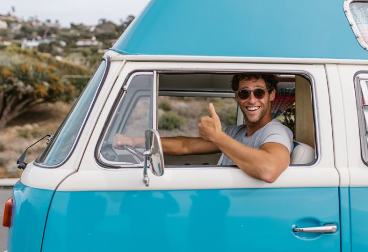 Maximaal campergewicht blije meneer in een blauw camperbusje