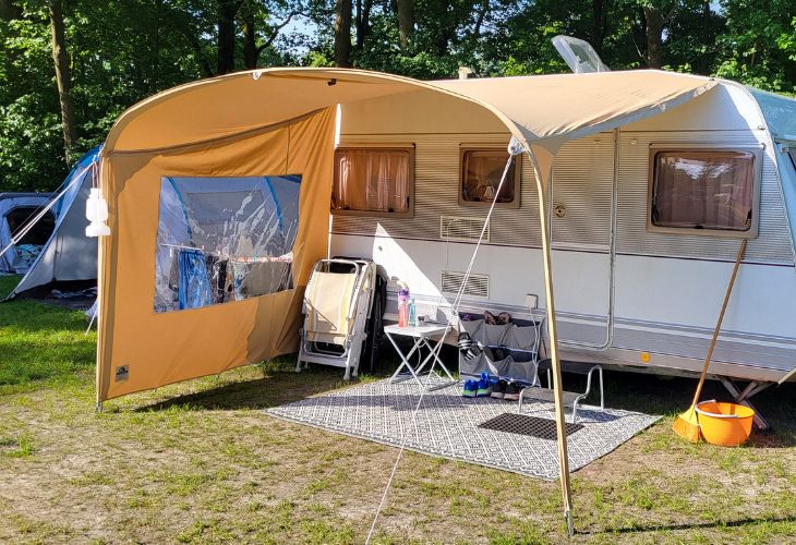 Karsten Touring Luifel opgezet aan de caravan vast klassiek beige