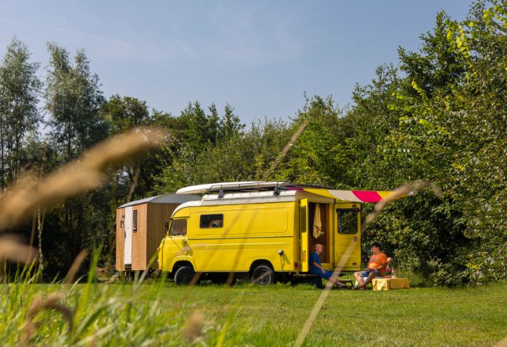 Huren bij de Boer gele camper op camping 